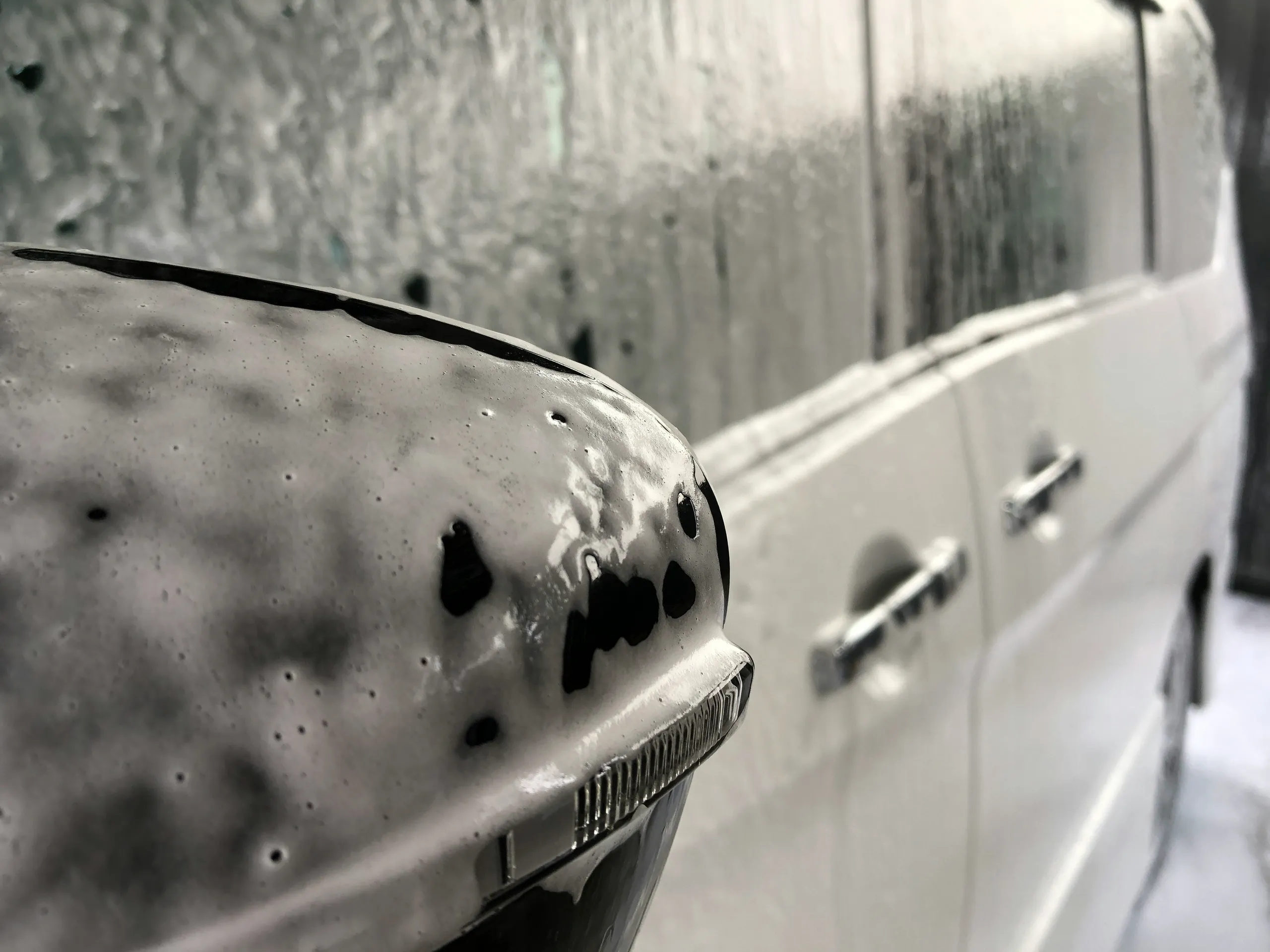 Auto w profesjonalnym garażu detailingu z rozpyloną wodą